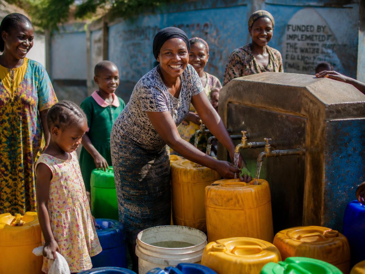 Community members in Nakuru filling jerrycans with clean treated water at a shared water point